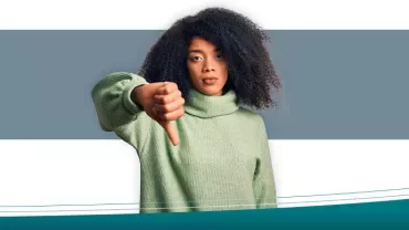 Persoon met groene trui geeft duim omlaag