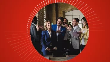 Een groep mensen applaudisseert in een kantooromgeving.