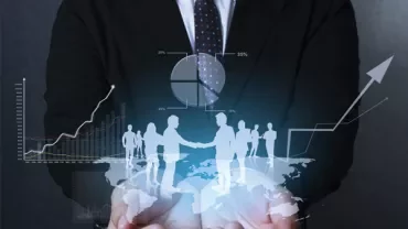 Person in suit holding holographic world map and charts.