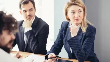 Group of people in a meeting sitting at a table.