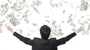 Person with arms raised as money bills fall from above.