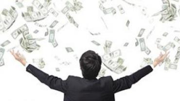 Person with arms raised as money bills fall from above.