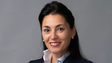 Professional portrait of an individual in a blue blazer with a white shirt.