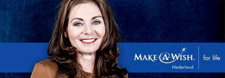 Person smiling, Make-A-Wish Nederland logo, blue background.