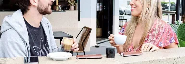 Two people enjoying coffee and chatting at a café.