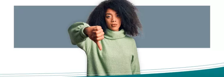 Person wearing green sweater giving thumbs down