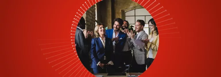 A group of people clapping in an office setting.