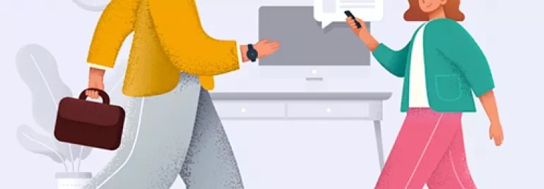 Two people talking near a desk with a computer.