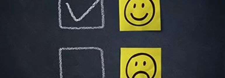 Two emoji faces next to checkboxes on a chalkboard
