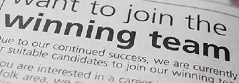 Close-up van een krantenadvertentie met de tekst 'join the winning team'.