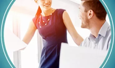 Twee collega's in gesprek op kantoor.