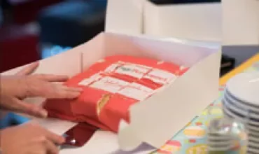 Taart in een doos met deksel gefotografeerd van opzij.
