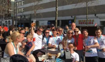 Groep mensen glimlacht tijdens een evenement, buiten zittend.